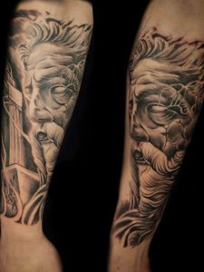 Black and grey tetovaža Zeusa na podlaktici
