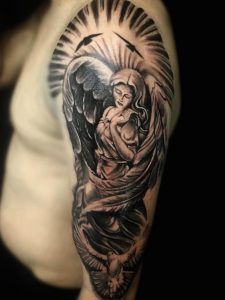 Realistična black and grey tetovaža anđela na nadlaktici